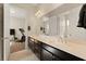 Bright bathroom featuring double sinks, dark wood cabinets, and a doorway leading to exercise area at 733 Aberdeen Tartan St, Las Vegas, NV 89138