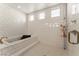 Bathroom featuring a glass enclosed shower, soaking tub and white tiled walls at 733 Aberdeen Tartan St, Las Vegas, NV 89138