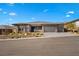 A single story home with a three car garage, desert landscaping and a paver driveway at 733 Aberdeen Tartan St, Las Vegas, NV 89138