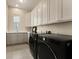 Modern laundry room with gray cabinets, quartz countertops, and front-load washer and dryer at 733 Aberdeen Tartan St, Las Vegas, NV 89138