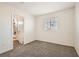 Clean bedroom with neutral walls, carpet, and a window, with a peek into an ensuite bathroom at 767 Durgos Dr, Henderson, NV 89012