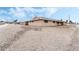 Side view of a single story home with a gravel yard and classic architecture under a partly cloudy blue sky at 845 Palo Verde Dr, Henderson, NV 89015