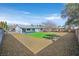 Wide shot of the backyard featuring covered patio, grass, and low maintenance rock landscaping at 865 Armada Pl, Boulder City, NV 89005