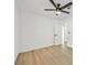 Bright bedroom featuring light hardwood floors, ceiling fan, and an ensuite bathroom at 865 Armada Pl, Boulder City, NV 89005