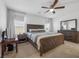 Bright bedroom with a large window, a ceiling fan, and a full wooden bedroom set at 9734 Cluny Ave, Las Vegas, NV 89178