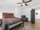 Comfortable bedroom featuring hardwood floors, a ceiling fan, and a comfy leather armchair at 9734 Cluny Ave, Las Vegas, NV 89178