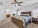 Bedroom featuring a ceiling fan, a large window, and an ensuite bathroom at 9734 Cluny Ave, Las Vegas, NV 89178