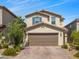 Two-story home featuring a neutral color scheme and a two-car garage, complemented by a well-maintained front yard at 9734 Cluny Ave, Las Vegas, NV 89178