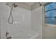 Close up of tiled bathtub with mounted shower head and stained-glass window at 1 Rising Sun Ct, Henderson, NV 89074