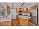 Well-lit kitchen featuring wooden cabinetry, stainless steel appliances, and a central island with tile countertops at 1 Rising Sun Ct, Henderson, NV 89074