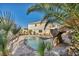 Inviting backyard pool area with rock waterfall feature and lush palm trees at 1 Rising Sun Ct, Henderson, NV 89074