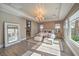 Spacious main bedroom with tray ceiling, chandelier, sitting area, and ensuite bathroom entrance at 11110 Mount Cass St, Las Vegas, NV 89141