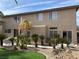 Back exterior featuring desert landscaping, artificial grass, and a raised patio at 11118 Scotscraig Ct, Las Vegas, NV 89141