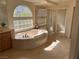 Spacious bathroom featuring a soaking tub, glass-enclosed shower, and marble countertops at 11118 Scotscraig Ct, Las Vegas, NV 89141