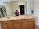 Spacious bathroom with double sink vanity, wooden cabinets, and large mirrors provides ample counter space at 11118 Scotscraig Ct, Las Vegas, NV 89141