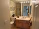 Bathroom featuring a framed mirror, wood vanity, and a shower with gold trim at 11118 Scotscraig Ct, Las Vegas, NV 89141
