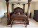 Elegant bedroom featuring a four-poster bed, matching furniture, and neutral carpet at 11118 Scotscraig Ct, Las Vegas, NV 89141
