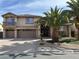Two-story home with a three-car garage, a small balcony, and desert landscaping at 11118 Scotscraig Ct, Las Vegas, NV 89141