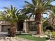 Well-maintained front yard with desert landscaping and decorative palm trees create curb appeal at 11118 Scotscraig Ct, Las Vegas, NV 89141