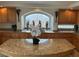 Kitchen with a large central island, wood cabinetry, granite countertops, and an arched window at 11118 Scotscraig Ct, Las Vegas, NV 89141