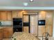 Kitchen featuring custom cabinetry, modern appliances, a refrigerator and granite countertops at 11118 Scotscraig Ct, Las Vegas, NV 89141