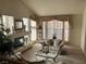 Bright living room with a fireplace, a decorative mirror and large windows with sheer curtains at 11118 Scotscraig Ct, Las Vegas, NV 89141