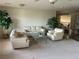 Carpeted living room with neutral-colored sofas, chairs, and a glass top coffee table featuring natural light at 11118 Scotscraig Ct, Las Vegas, NV 89141