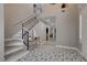 Open foyer with unique tile flooring, staircase, and neutral color palette at 2010 Spruce Brook Dr, Henderson, NV 89074