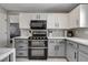 Well-lit kitchen featuring a stainless steel oven, microwave, and two-tone cabinets at 2010 Spruce Brook Dr, Henderson, NV 89074