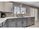 Modern kitchen with stainless steel dishwasher, stylish gray cabinets and white countertops at 2010 Spruce Brook Dr, Henderson, NV 89074