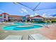 Inviting outdoor pool area with lounge chairs, umbrellas, and a beautiful view of the community building at 2215 Bensley St, Henderson, NV 89044