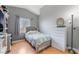 Bedroom with tufted headboard, wood laminate flooring, and double hung windows at 2241 Verde Cape Ave, Henderson, NV 89052