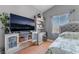 Comfortable bedroom featuring neutral paint, wood laminate flooring, and large TV at 2241 Verde Cape Ave, Henderson, NV 89052