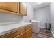 Laundry room with upper and lower wood cabinets and white appliances at 2241 Verde Cape Ave, Henderson, NV 89052