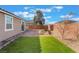 A manicured backyard with artificial turf, a brick patio, and desert landscaping at 2910 Ventana Ridge Ave, Henderson, NV 89044