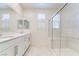 Bright bathroom featuring double sinks with white cabinets and a glass-enclosed shower with seating at 2910 Ventana Ridge Ave, Henderson, NV 89044