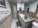 A renovated bathroom is equipped with a large framed mirror, granite countertop and white cabinets at 2913 Domino Way, Las Vegas, NV 89117