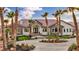 Stunning single-story home featuring stone accents, a tile roof, a circular driveway, and lush palm tree landscaping at 2925 Hidden Hollow Cir, Logandale, NV 89021