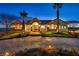 Well-lit desert home at dusk with manicured lawns and mature landscaping at 2925 Hidden Hollow Cir, Logandale, NV 89021