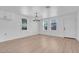 Open living room with hardwood floors, three windows, and a modern chandelier, creating a welcoming and bright atmosphere at 3049 Cedar St, Las Vegas, NV 89104