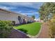 Inviting backyard with lush green lawn, mature tree, and view of the main house at 344 E Rush Ave, Las Vegas, NV 89183