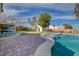 Outdoor oasis featuring a pristine pool, covered patio, and a lush, green lawn perfect for entertaining and relaxation at 344 E Rush Ave, Las Vegas, NV 89183