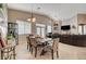Open-concept dining area features a wooden table, neutral tones, and ample natural light adjacent to a large living room at 344 E Rush Ave, Las Vegas, NV 89183