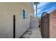 Beige stucco house with a metal shed, small window and black metal fence along the side yard at 344 E Rush Ave, Las Vegas, NV 89183