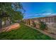 A lush green backyard featuring a stone patio and perimeter landscaping at 4664 Stuttgart St, Las Vegas, NV 89147