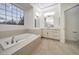 Bright bathroom featuring a soaking tub, vanity with double sinks, and tile floors at 4664 Stuttgart St, Las Vegas, NV 89147