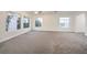 Large living room with neutral carpet, a ceiling fan, and multiple bright windows at 4664 Stuttgart St, Las Vegas, NV 89147