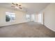 This airy living room has a ceiling fan, neutral carpet, and several windows at 4664 Stuttgart St, Las Vegas, NV 89147