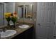 Bright bathroom features a double granite vanity, decorative flowers, large mirror, and neutral wall color at 5705 Petrified Tree Ln, North Las Vegas, NV 89081