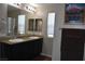 Bathroom features double sinks with granite countertops, a large mirror, and natural light at 5705 Petrified Tree Ln, North Las Vegas, NV 89081